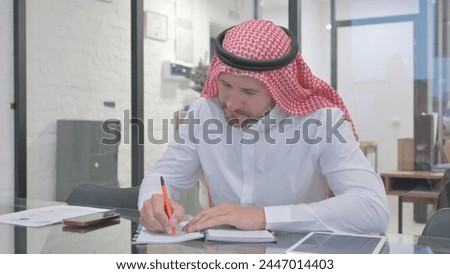 Middle Aged Muslim Man Writing in a Diary