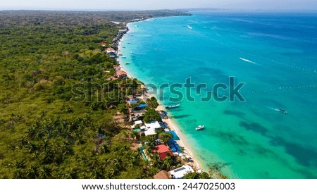 Aerial view of Playa Blanca, Baru, showcasing the vibrant turquoise waters, lush greenery, and beachfront properties