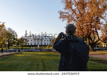 Tourists taking pictures of the White House.  Using mobile phone to capture  the iconic symbol of American democracy , Washington DC