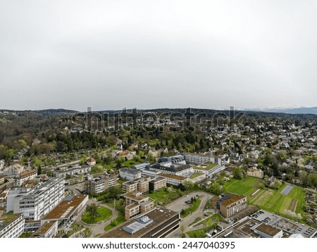 Aerial view over Swiss City of Zürich with hospitals and woodland in the background on a cloudy spring day. Photo taken April 7th, 2024, Zurich, Switzerland.
