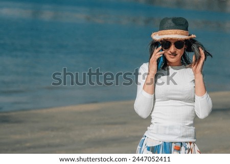 young woman talking on mobile phone on the beach