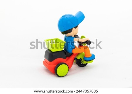 Toy boy with cap riding cycle isolated on white background