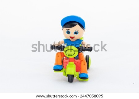 Boy wearing blue cap riding tricycle toy for kids on white background