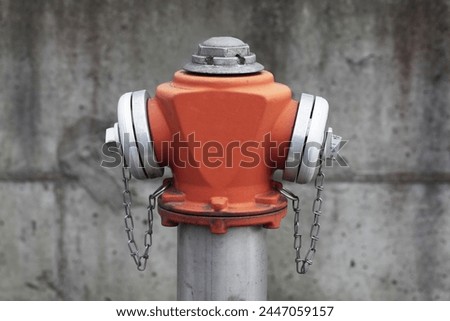 Red paint fire hydrant. Isolated on gray concrete. Fire department water supply for emergency. Brand new shiny vibrant red valve. Industrial factory emergency water supply.