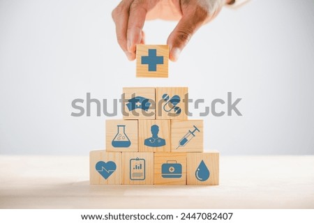 Captured moment, Hand gripping a wooden block showcasing healthcare and medical icons. Depicting safety, health, and family care, symbolizing pharmacy and heart well-being. health care concept