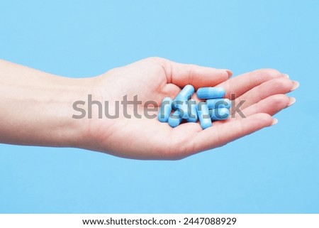 Medicine background. Blue pills isolated on blue. Pile of capsules. Tablets background. Vibrant vivid color drugs. Antibiotics background. Holding blue pills. Drugs on hand. Diet supplementation. Royalty-Free Stock Photo #2447088929