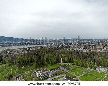 Aerial view over Swiss City of Zürich with woodland and Lake Zürich with local mountain Uetliberg in the background on a cloudy spring day. Photo taken April 7th, 2024, Zurich, Switzerland.