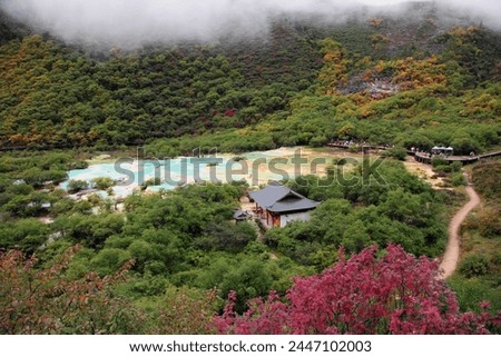 Jiuzhaigou, Sichuan, China, Asia - 09 22 2010 : Exterior aerial photo view of  landscape of Jiuzhaigou valley with its colorful foliage of trees and chinese temple building pagoda with turquoise water