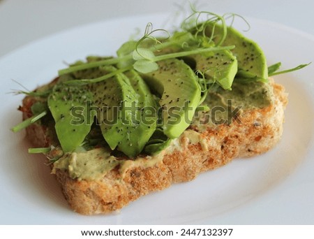 Vegetarian Sandwich Recipe Stock Photo. Yeast Free Toast With Sliced Spicy Avocado Under Peas Grass On White Plate
