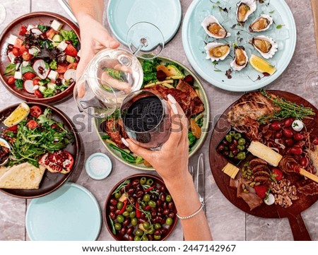 A picture of a table filled with a variety of food dishes. The pictures show two people beating cups together to express their achievement.