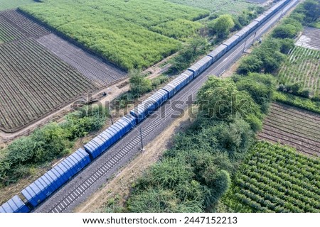 Aerial footage of a freight train in the countryside near Pune India. Royalty-Free Stock Photo #2447152213