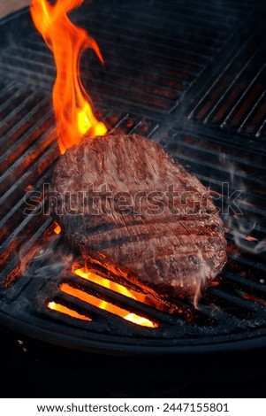 Traditional American barbecue flanksteak steak as close-up on a charcoal grill with fire  Royalty-Free Stock Photo #2447155801
