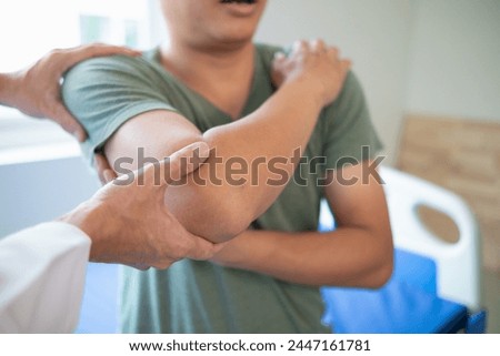 man was admitted for treatment of muscle pain in back of his shoulder due to working hard and causing muscle inflammation. doctor is treating man muscle pain in his back and shoulders due to overwork. Royalty-Free Stock Photo #2447161781