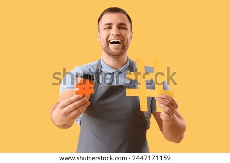 Male barista with hashtags and coffee cup on yellow background