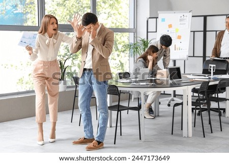 Angry businesswoman shouting at coworker in office Royalty-Free Stock Photo #2447173649