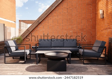 A cozy setup of a couch and chairs on a wooden deck, surrounded by nature, perfect for relaxing or entertaining outdoors