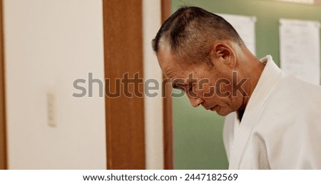 Aikido, sensei and bow with respect for Japanese history, culture and martial arts at traditional gym. Mature man, aikidoka with humble greeting or custom welcome to challenge, class or fight at dojo Royalty-Free Stock Photo #2447182569
