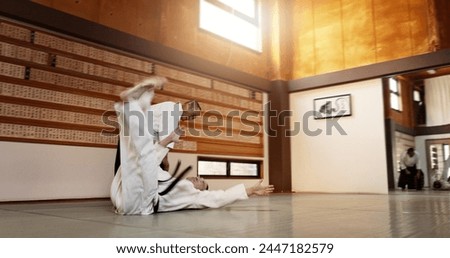 Black belt students, throw or sensei in dojo to start practice lesson, discipline or teaching self defense. Japanese master, people learning combat or athletes in fighting class, training or aikidoka Royalty-Free Stock Photo #2447182579