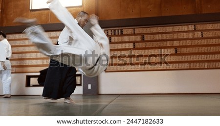 Japanese students, throw or sensei in dojo to start practice lesson, discipline or teaching self defense. Black belt master, people learning combat or athletes in fighting class, training or aikidoka Royalty-Free Stock Photo #2447182633