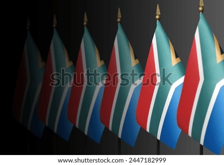 Row of South African flags on a dark background in perspective Royalty-Free Stock Photo #2447182999
