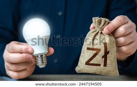 Polish zloty money bag and burning idea light bulb in the hands of a man. Investment in an idea. Offering financial incentives to enhancing energy efficiency. Reduce carbon footprint.