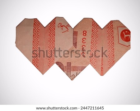 Ten Malaysia Ringgit folded into double hearts isolated on a white background. Love the money concept.