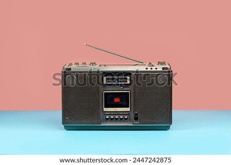 Front view, Retro outdated portable stereo boombox radio cassette recorder on colorful background, vintage old cassette radio with antenna on mint blue floor.