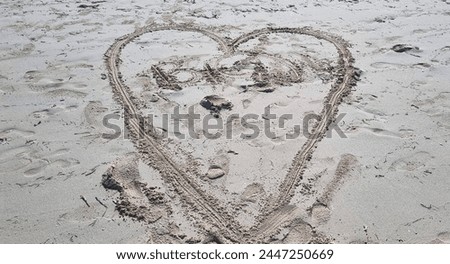 Heart shape drawn in the sand of the beach