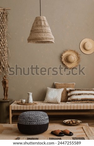 Stylish composition of boho ethno living room with daybed, pillows, hanging decoration, carpet, basket, beige accessories. Home decor. Template.	
 Royalty-Free Stock Photo #2447255589