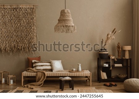 Stylish composition of boho ethno living room with daybed, blak shelf, pillows, decoration, beige accessories. Home decor. Template. Textured wall.	 Royalty-Free Stock Photo #2447255645