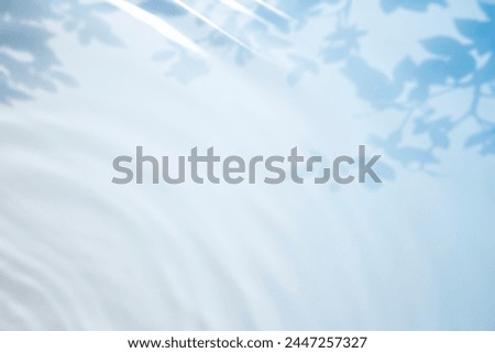 Gradient blue water background image with tropical leaf shadow. Use it as a picture of the summer atmosphere.