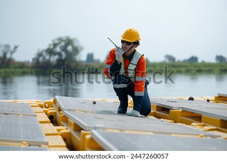 A professional engineer in safety gear is inspecting and maintaining solar panels at a renewable energy power plant.