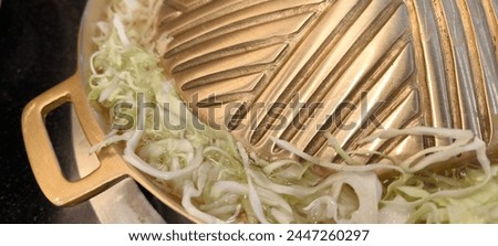 Cook food in a brass pan. Royalty-Free Stock Photo #2447260297