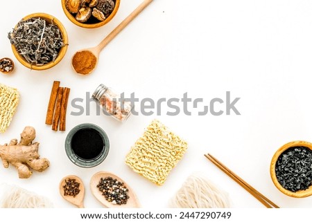 Geometric design. Traditional Asian cuisine. Rice vermicelli, noodles, ginger, spices, salt, pepper, weeds, cinnamon pattern to cook Chinese and Japanese food on white background top view copy space