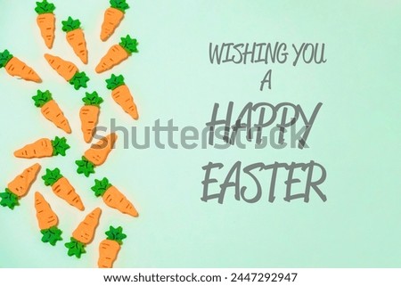 A bunch of carrots are scattered across a green background. The image is a creative and whimsical way to wish someone a happy Easter