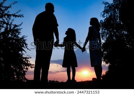 Happy family together at sunset silhouette