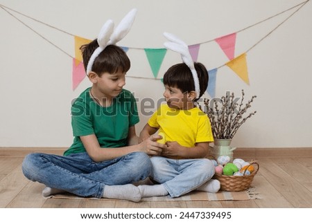 Children bunny ears hold Easter eggs their hands and laugh.Easter photo shoot.