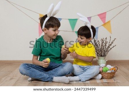 Children bunny ears hold Easter eggs their hands and laugh.Easter photo shoot.
