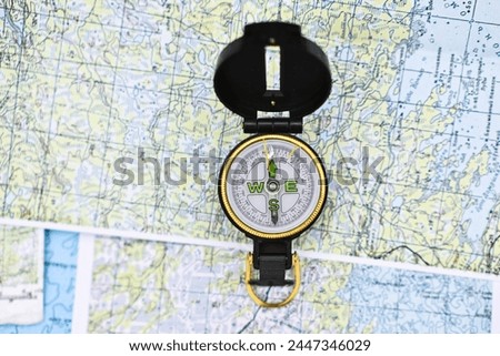 Map and compass. The magnetic compass is located on a paper navigation map.