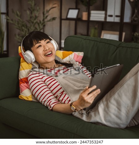 Woman Japanese female sit at home use digital tablet to watch movie or have video call