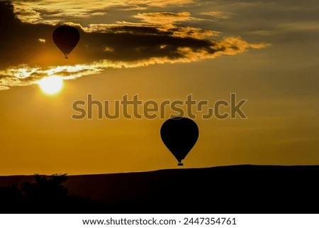 Hot air balloons taking off at sunrise in Cappadocia, "the land of beautiful horses"