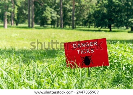 Sign on the lawn with the inscription: danger ticks.