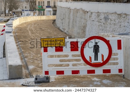 Sidewalk under construction. The inscription: "CROSS THE OTHER SIDE OF THE STREET". A newly built sidewalk, but not yet operational. Road sign: "pedestrian traffic prohibited". A city under renovation
