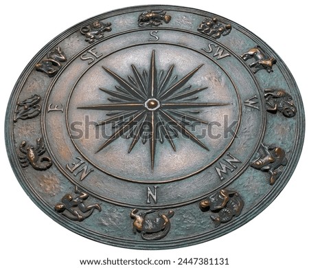 fragment decorative compass points with north, south, east, and west on the cement ground with horoscope elements of zodiac signs isolated on white with clipping path