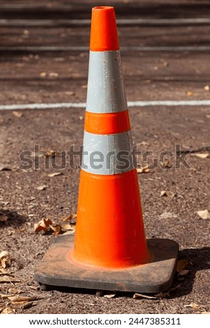 An orange traffic safety cone with reflective tape placed in a parking area at Zion National Park, Utah.