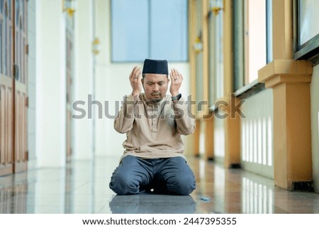 Eid Mubaruk, Ramadan, Muslim, Isalam, An Asian Muslim man is praying with peace in the beautiful mosque, giving a powerful atmosphere of faith, with copy space, Islam concept.	