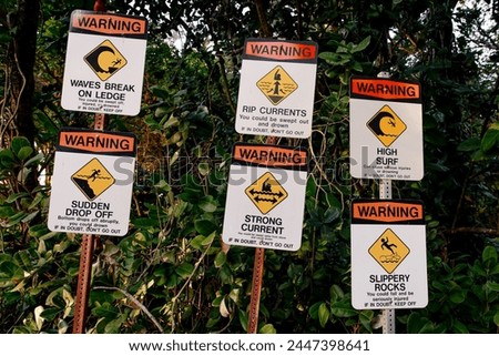 assorted warning signs about dangerous beach conditions  Royalty-Free Stock Photo #2447398641