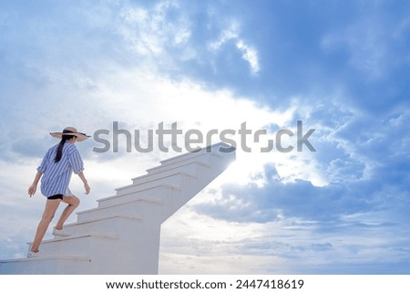 A woman walking up a wooden staircase at sunset.