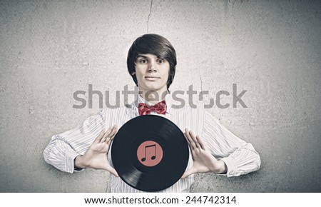 Young handsome man dj holding disco plate