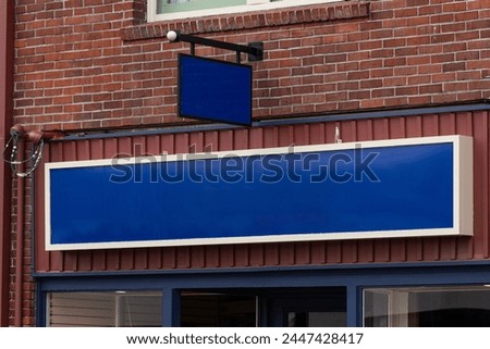 Empty blue banner sign board on a brick wall building, great for commercial advertising and to customize your own text